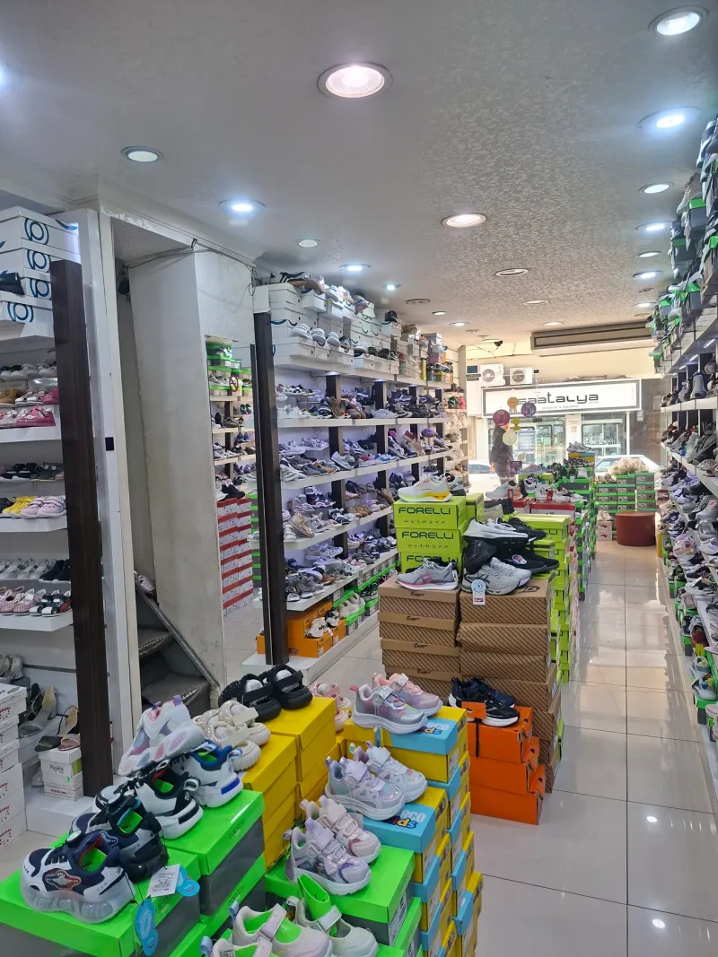 Mağazada duvar boyu ayakkabı rafları ve kutu istifleri