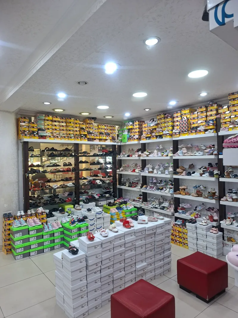 Mağazada renkli spor ayakkabı ve sandaletlerin dizildiği raflar